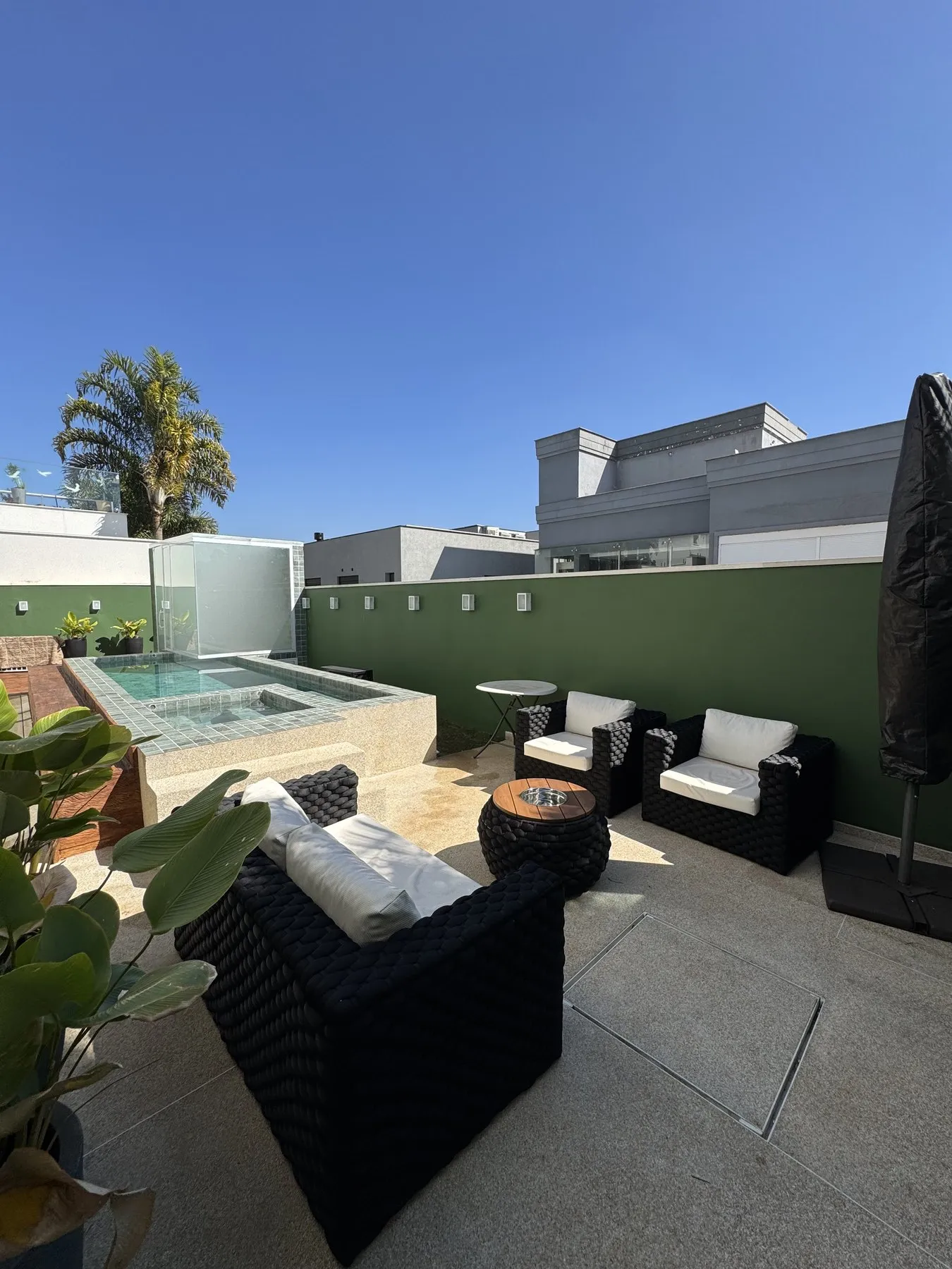 Área de estar com sofás ao lado da piscina